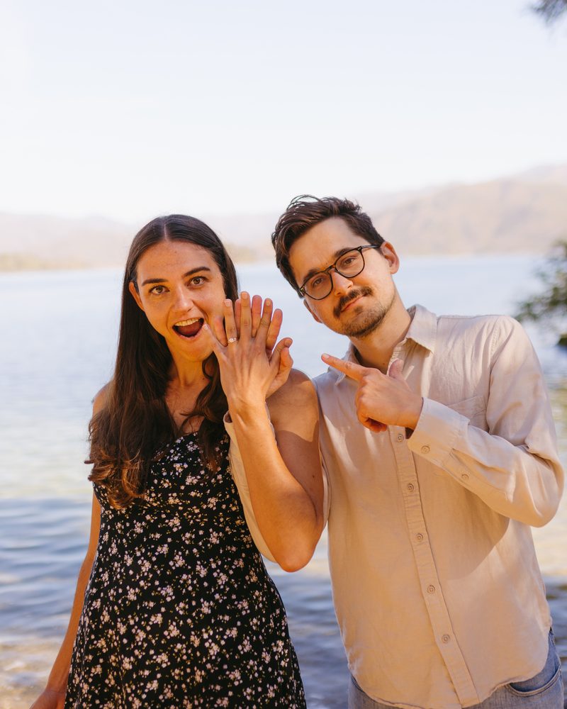 Andrea showing her ring to the camera while Alex points at it