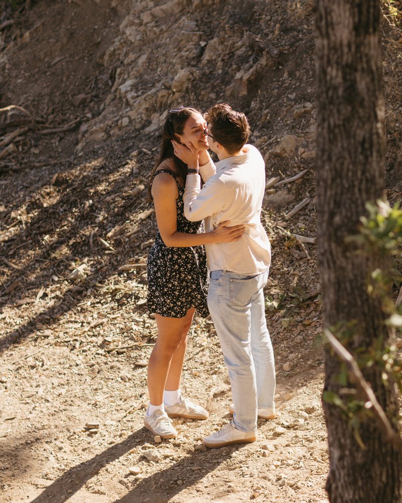 Andrea and Alex kissing on the trail in the afternoon light