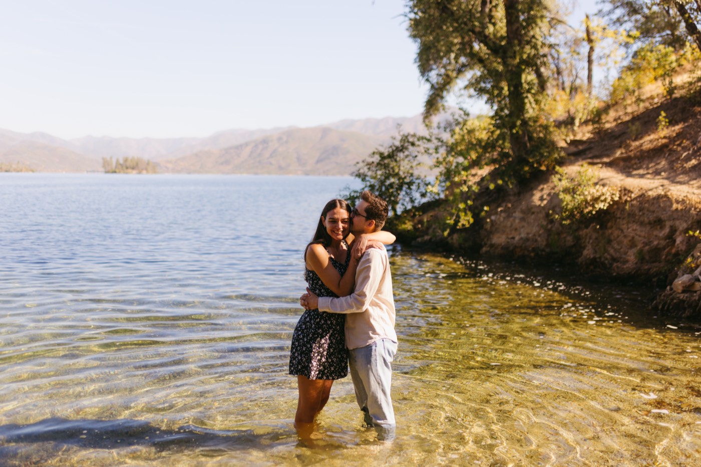 Andrea and Alex embracing, standing in the shallows of the lake