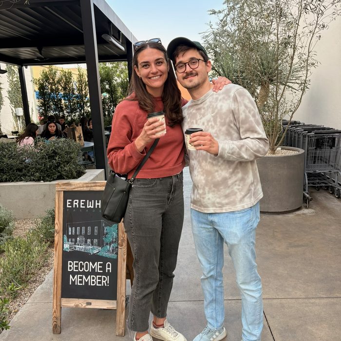 Andrea and Alex holding coffees outside a caf&eacute;
